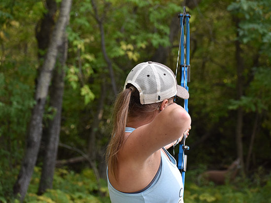 Woman shooting archery bow