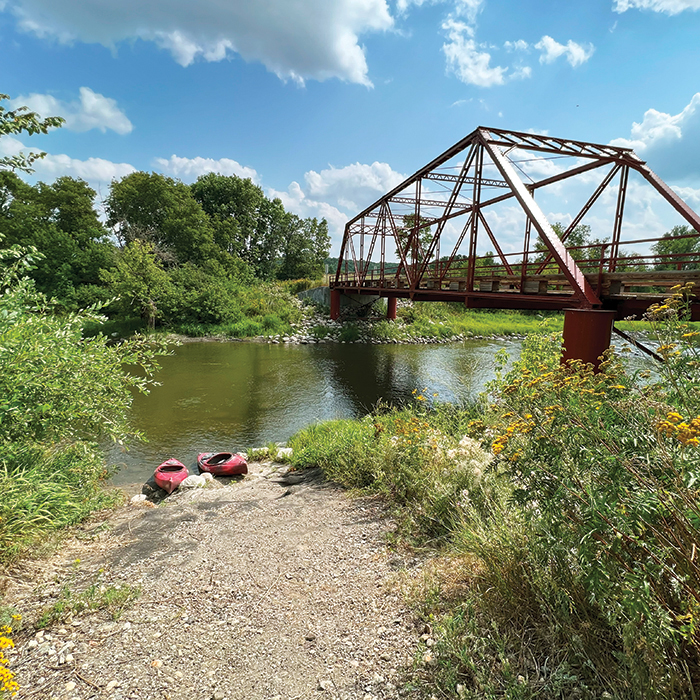 Kayaks along the shore of the Pembina River with the historic Brickmine Bridge in view 